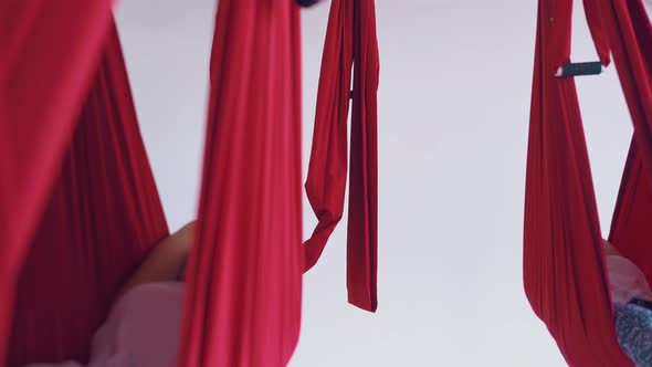 Ladies Practice Modern Aerial Yoga Pose Lying in Hammocks