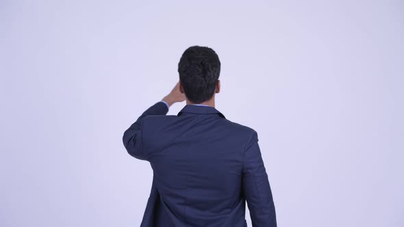 Rear View of Young Indian Businessman Directing and Pointing Finger