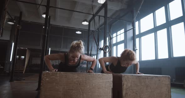 Slow Motion Two Young Beautiful Female Athletes Working Out Doing Pushups and Clapping Together in