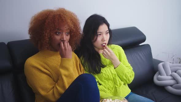 Multiracial Friendship. Afican American Black and Asian Woman Eating Popcorns and Watching Movies