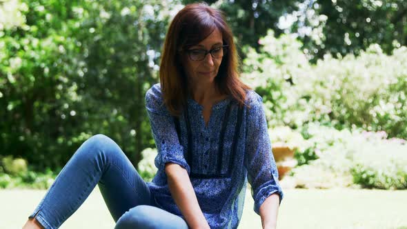 Mature woman reading a book in the garden