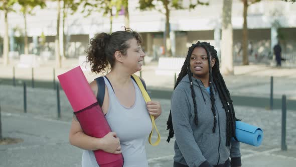 Diverse Friends Walking Home Through City Streets After Training