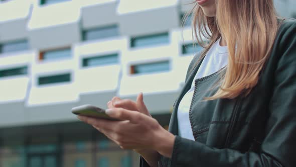 Young Attractive Girl in Stylish Clothes on the Background of a Modern Building