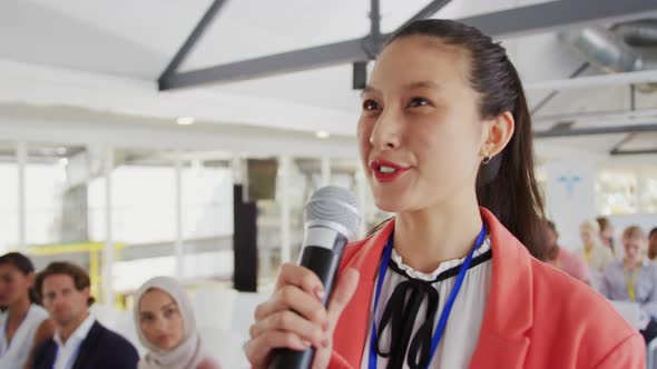 Female audience member at a business conference asking a question