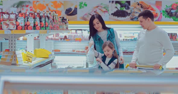 Family with Child Choosing Food in the Section of Frozen Products