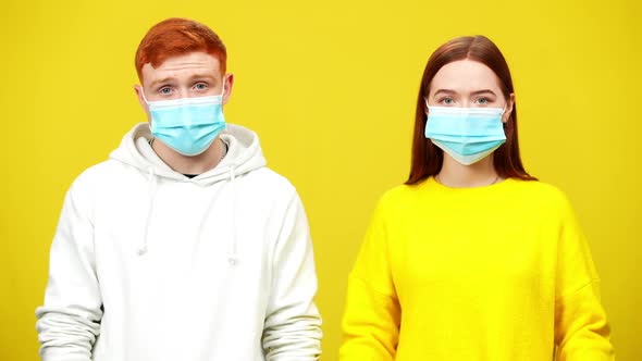 Redhead Millennial Man and Woman Taking Off Covid19 Face Masks and Smiling Looking at Camera