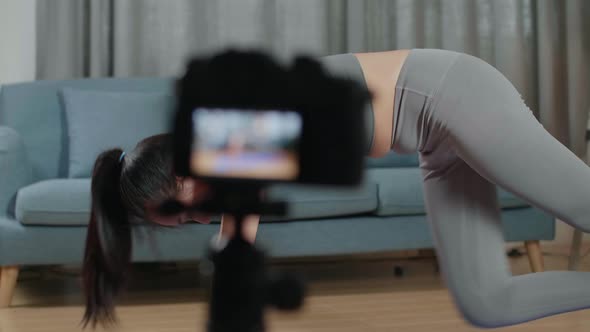 Asian Trainer Female Speaking To Camera And Stretching While Recording Teaching Exercise At Home