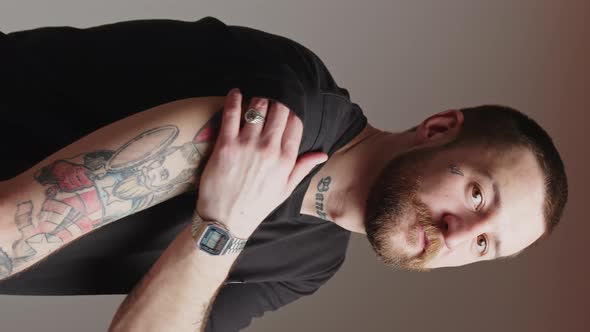 a Serious Bearded Attractive Young European Man Showing His Tattooed Hand Vertical Video Gradient