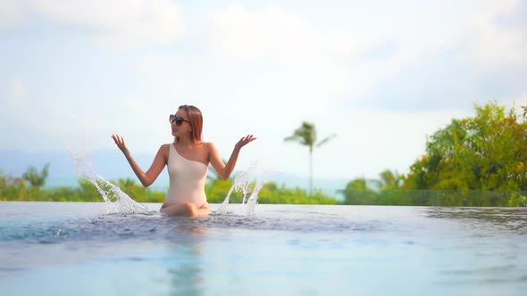 Young asian woman enjoy around outdoor swimming pool for leisure