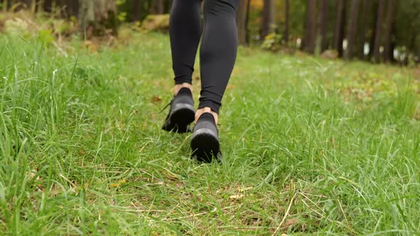 Young Woman in Sneakers Running in Autumn Forest