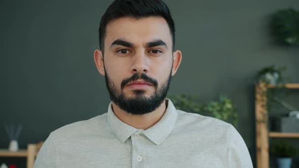 Slow Motion Portrait of Serious Middle Eastern Man Looking at Camera at Home