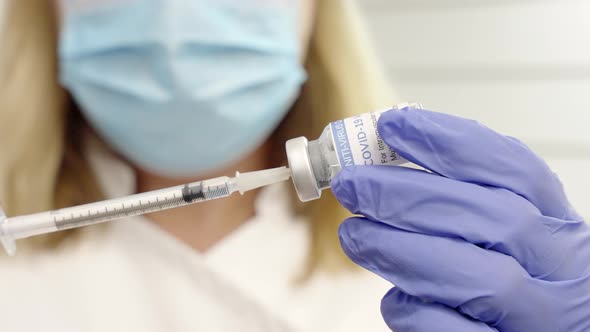 close shot of female with a coronavirus vial and syringe