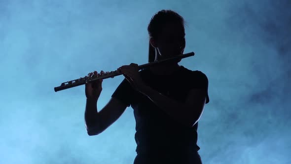 Professional Musician Female Playing on Flute. Smoky Studio, Slow Motion