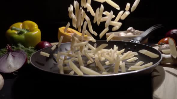 Frying Pan with Raw Pasta Macaroni. Fall in Slow Motion