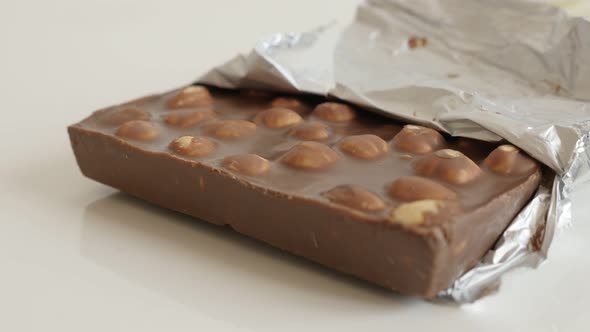 Milk chocolate with whole hazel nuts slow tilt 4K 2160p 30fps UltraHD footage - Fine texture of tast