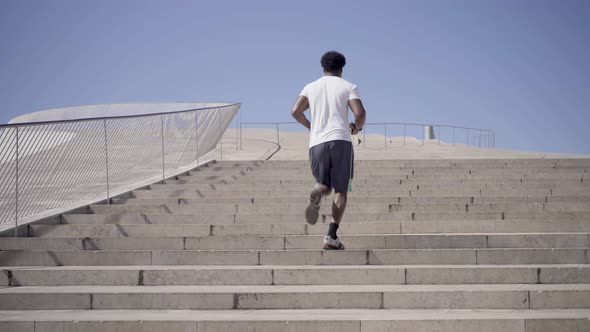 Rear View of African American Man Running Upstairs