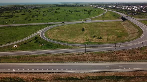 Aerial View of Modern Highway Road Intersection with Traffic Circle on Rural Landscape