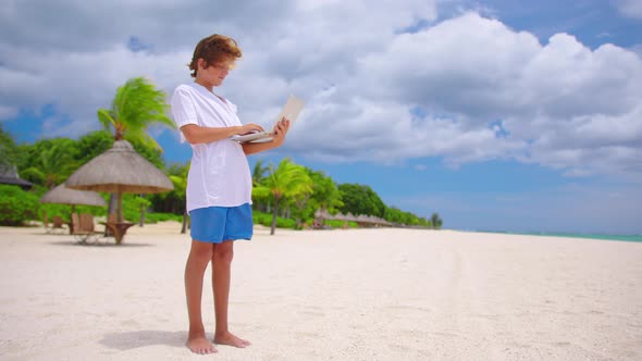 Man is Typing on the Keyboard on the Background of a Beautiful Beach