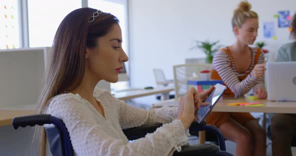 Side view of young Caucasian disabled female working on digital tablet in modern office 4k