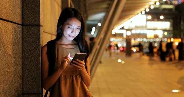 Woman use of smart phone in city at night 