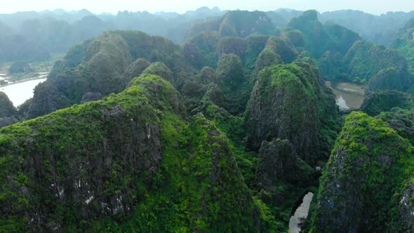 Aerial: North Vietnam karst landscape at sunset, drone view of Ninh Binh region, tourist destination