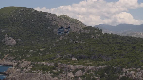 Private Helicopters Flying Over Sea and by Cliffs Cascading into the Water