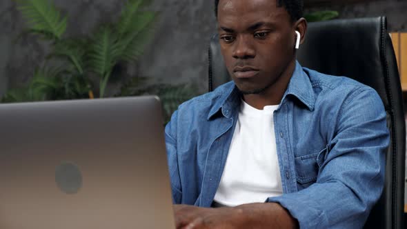 African American Man Works for Laptop Online Chatting with Company Employees