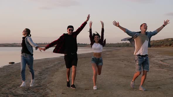 Group of Friends Running Happily Together on the Beach