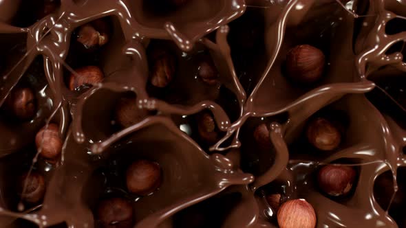 Super Slow Motion Shot of Hazelnuts Falling Into Melted Chocolate at 1000 Fps