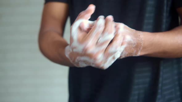 Young Man Washing Hands with Soap Warm Water