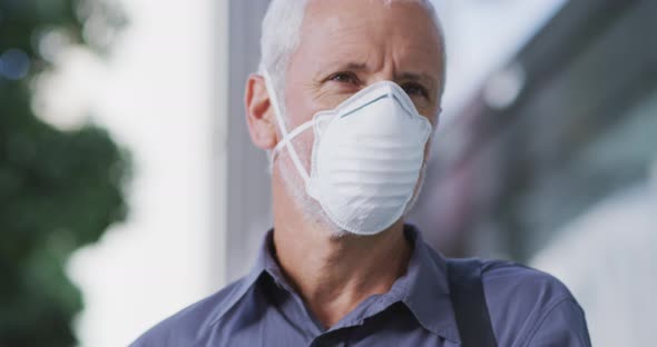 Caucasian man out and about in the street wearing on a face mask against coronavirus