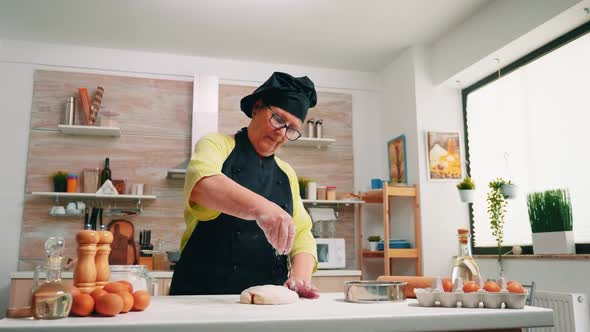 Cook Sprinkling a Piece of Dough with Flour