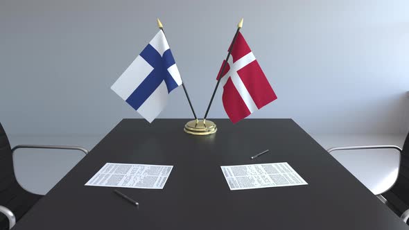 Flags of Finland and Denmark and Papers on the Table
