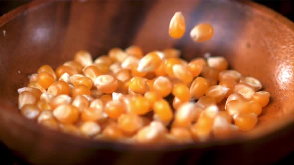 Super Slow Motion Popcorn Grains Fall Into a Wooden Plate