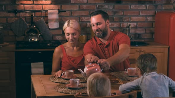 Friendly Family Gathered in a Cozy Evening in the Kitchen for Dinner with a Delicious Pie