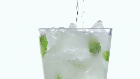 Pouring Soda into a Glass with the Ice Cubes