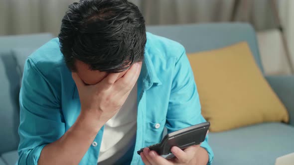 Close Up Of Asian Man With A Laptop Holding Bill And Calculator To Calculate Money At Home