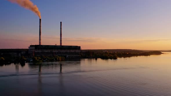 Aerial view of industry near river. Aerial drone view of factory near river during sunset