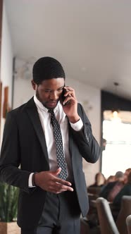 African American Businesman in Suit Talking By Phone in Cafe