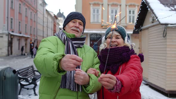 Elderly Family Holding Sparklers Bengal Lights Enjoying Christmas Eve on Winter City Center Street