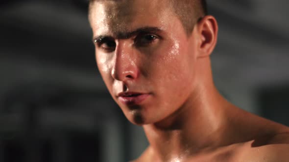 Portrait of attractive athletic man breathing heavily in fitness studio