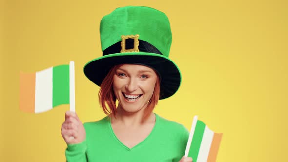 Woman with hat holding Irish flags