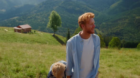 Happy Father Leading Son By Hand Walking Hill Closeup