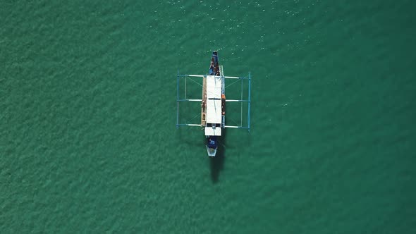Aerial Shot of a Filipino Banca Boat Floating in Turquoise Pristine Water