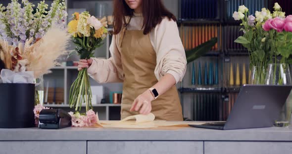 Woman Florist Creates a Bouquet of Flowers for Sale.