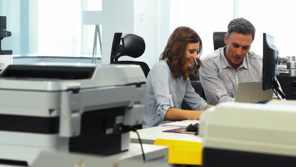 Business colleagues discussing over laptop