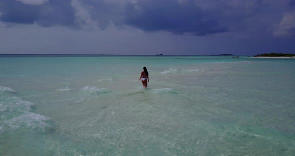 Pretty smiling lady relaxing having fun on the beach on sunny blue and white sand background 4K