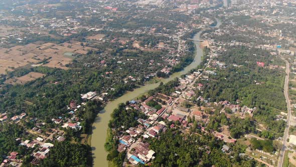 Aerial clip of the muddy waters of Sangkae River in Battambang Cambodia during a summer day