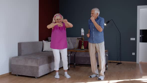 Senior Mature Couple Dancing Together in Room at Home During Quarantine Lockdown for Coronavirus