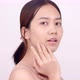 Slow motion of Asian girl with natural make up looking to camera and patting her face gently. - VideoHive Item for Sale